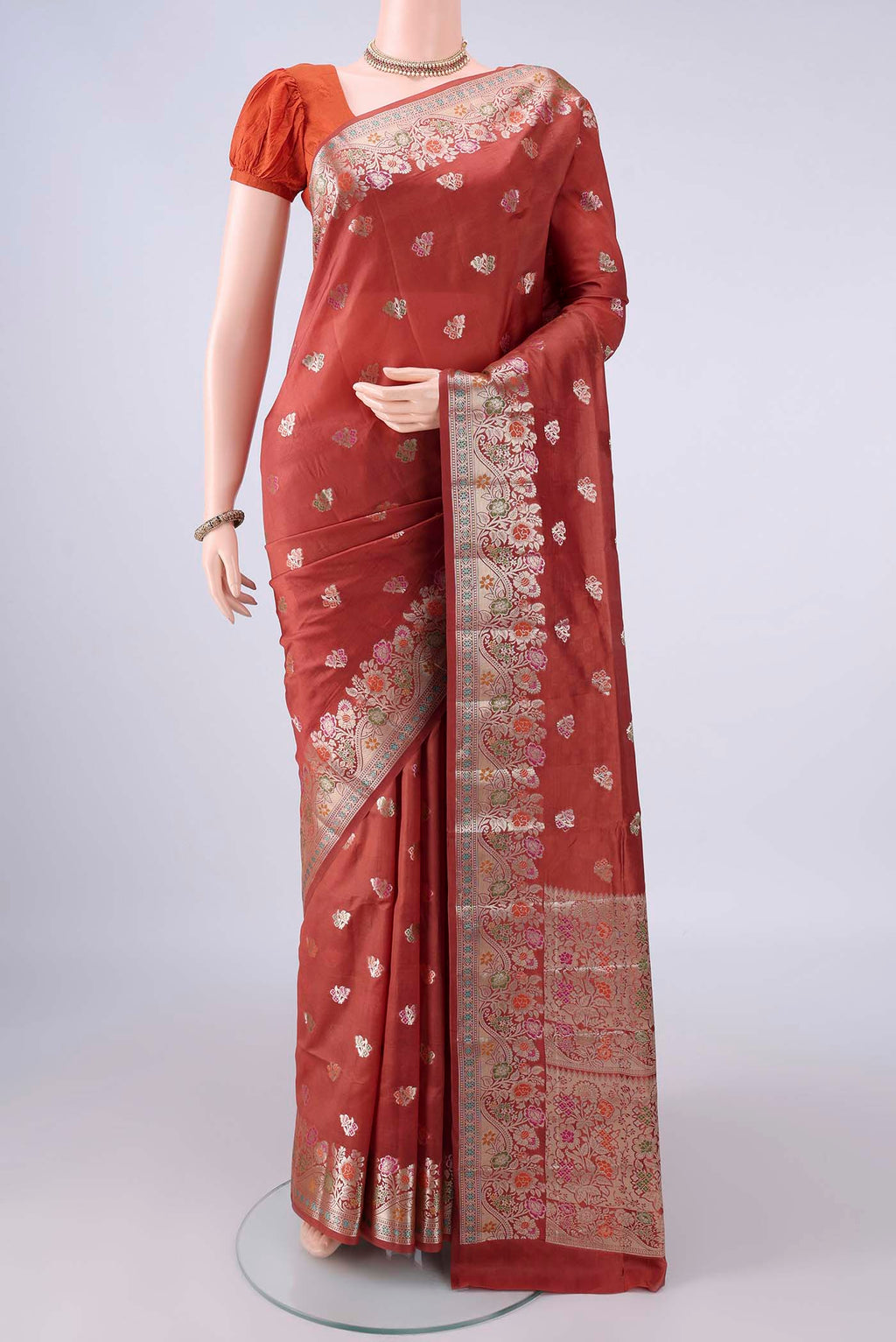 Pure Silk Rust Banarasi Raw Saree with Zari Butta on the body and Zari And Thread Border.  displayed on a mannequin