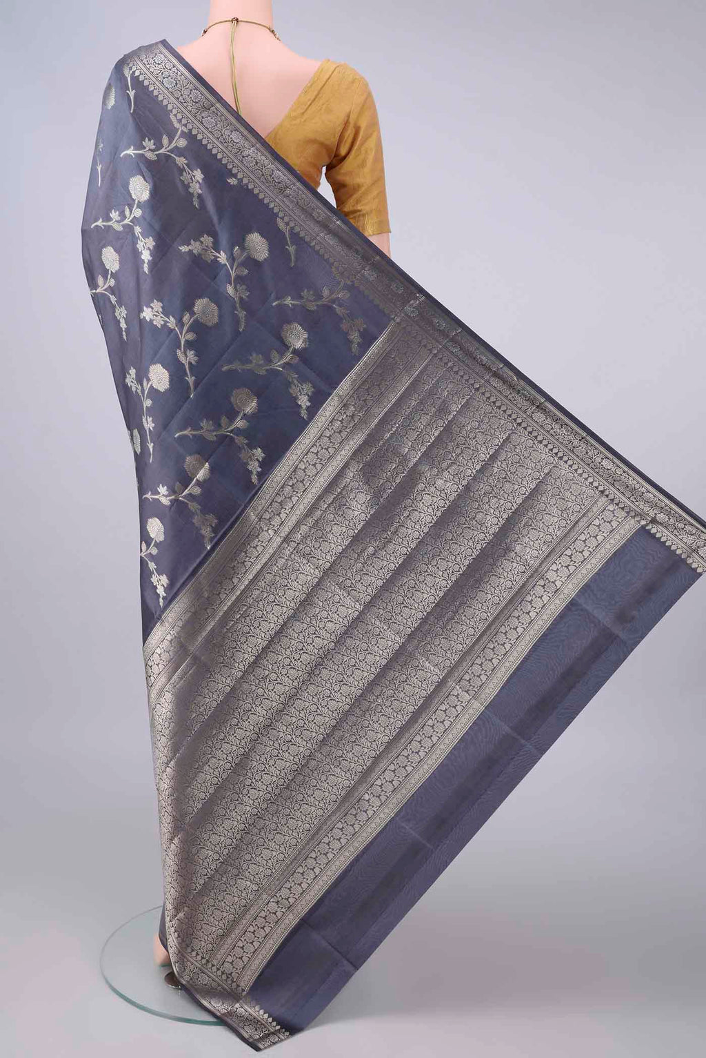 Flat view of Pure Silk Davys Grey Banarasi Raw Saree with Zari Butta on the body and Zari Border. 