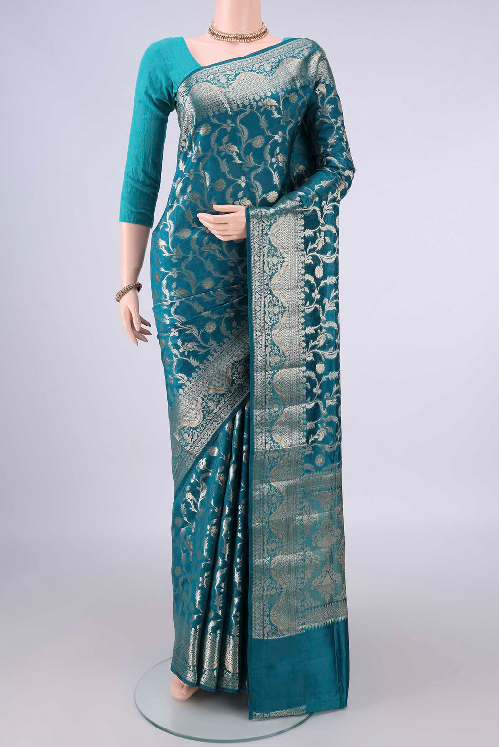 Pure Silk Teal Banarasi Raw Saree with Zari Butta on the body and Zari Border.  displayed on a mannequin