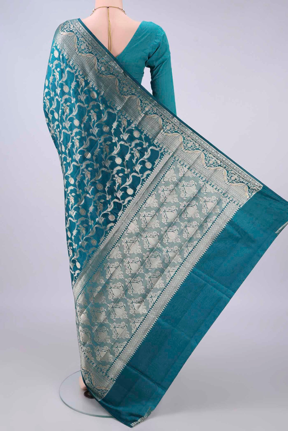 Flat view of Pure Silk Teal Banarasi Raw Saree with Zari Butta on the body and Zari Border. 