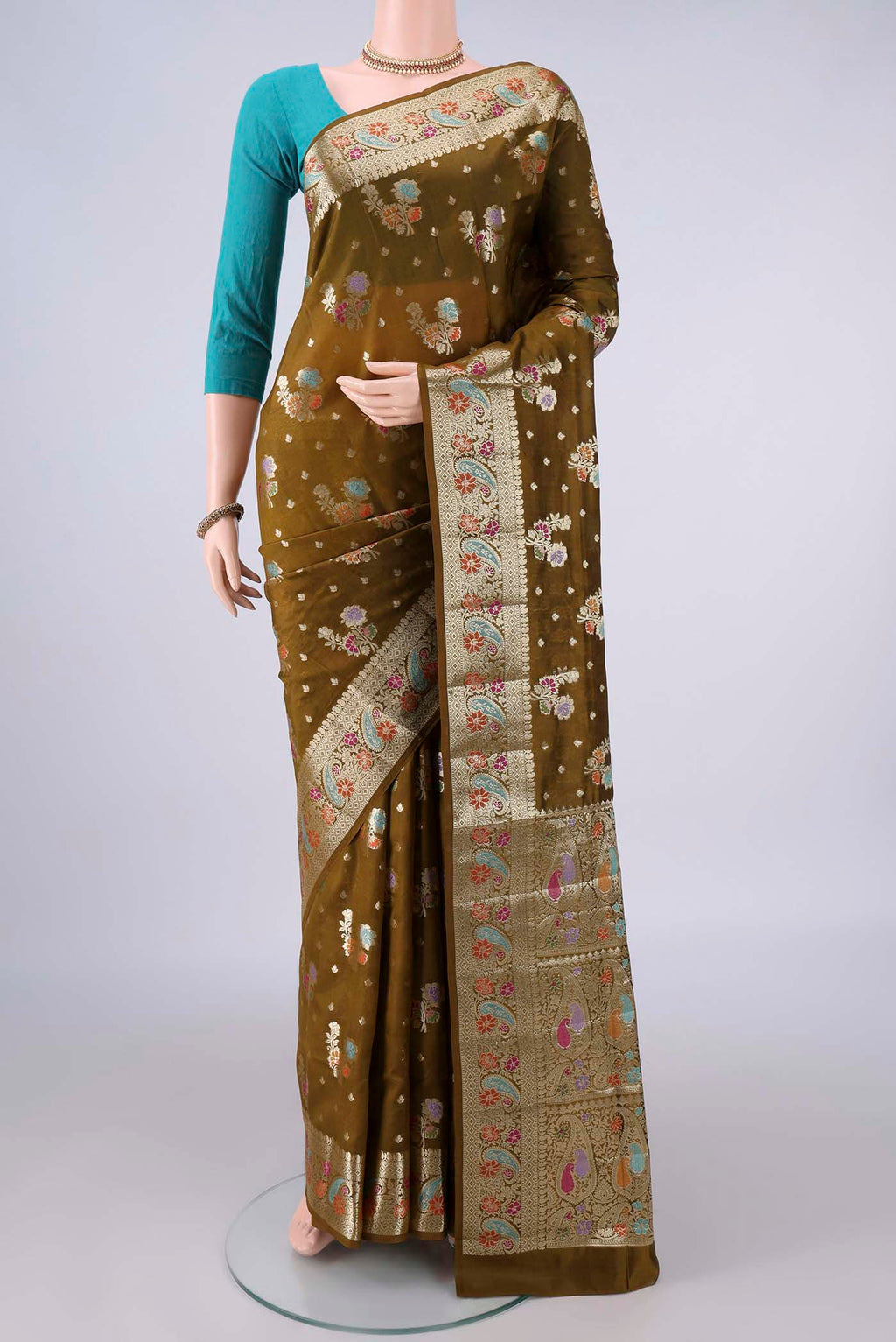 Pure Silk Mehandi Green Banarasi Raw Saree with Zari And Thread Butta on the body and Zari And Thread Border.  displayed on a mannequin