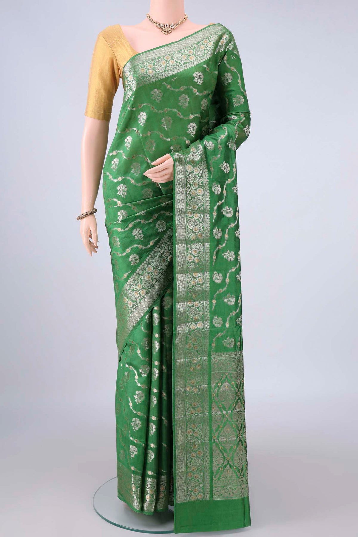 Pure Silk Green Banarasi Raw Saree with Zari Butta on the body and Zari Border.  displayed on a mannequin