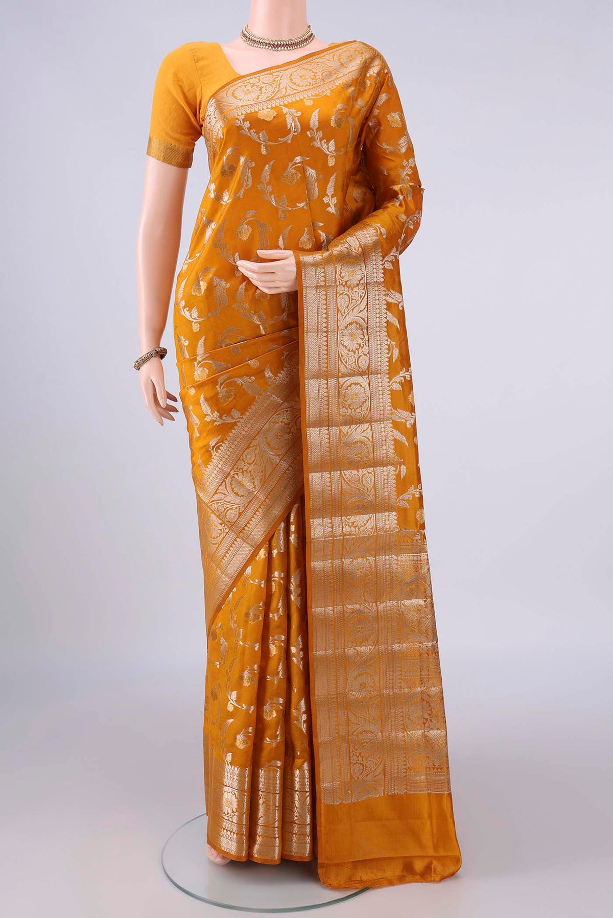 Pure Silk Mustard Banarasi Raw Saree with Zari Butta on the body and Zari Border.  displayed on a mannequin