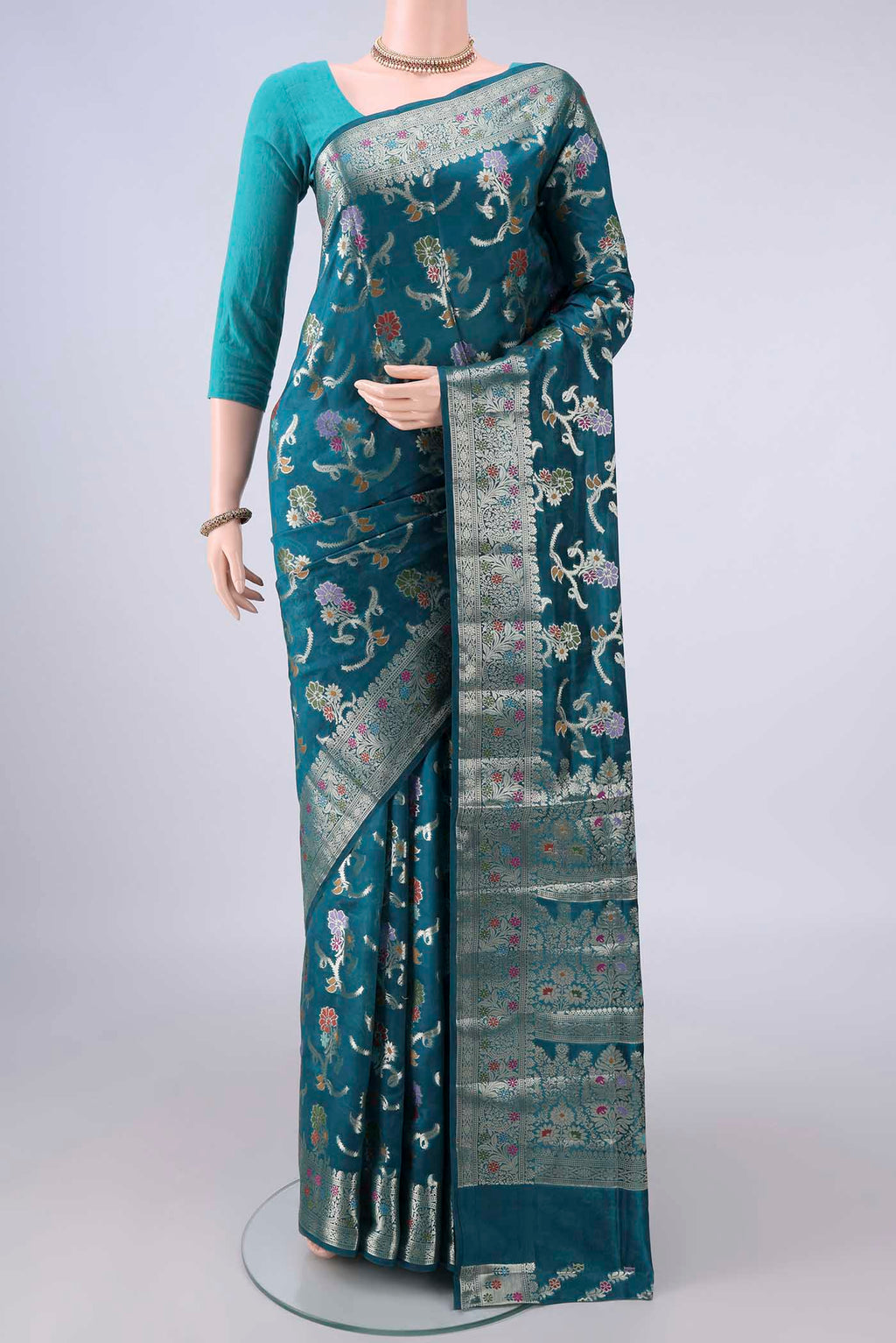 Pure Silk Teal Banarasi Raw Saree with Zari And Thread Butta on the body and Zari And Thread Border.  displayed on a mannequin