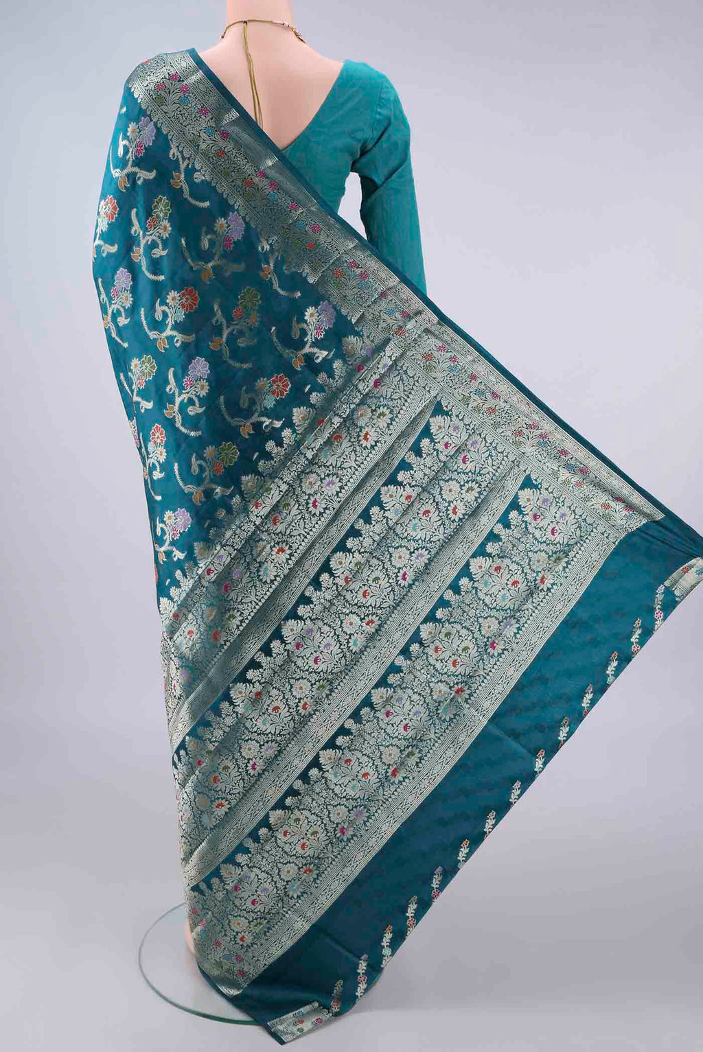 Flat view of Pure Silk Teal Banarasi Raw Saree with Zari And Thread Butta on the body and Zari And Thread Border. 