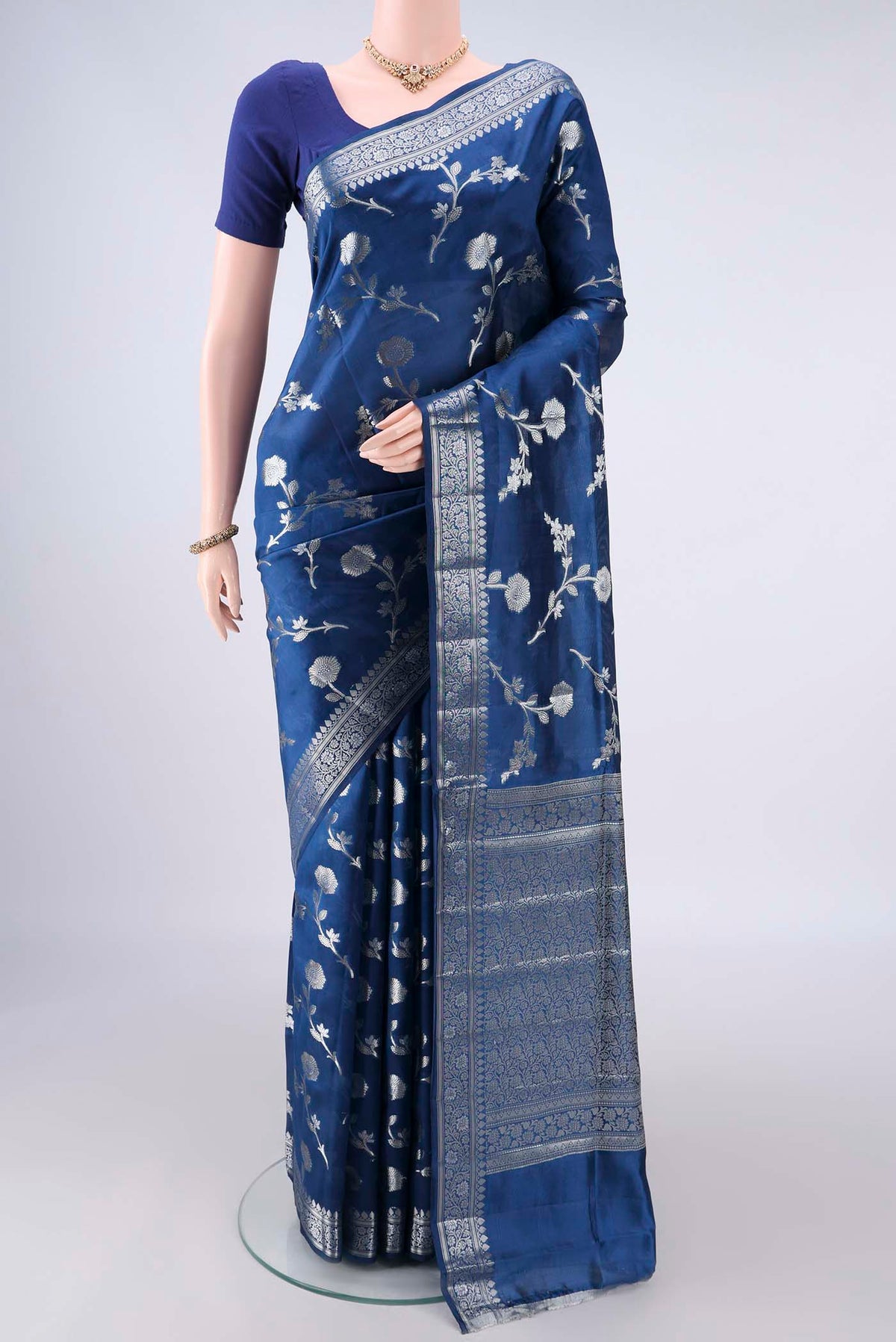 Pure Silk Blue Banarasi Raw Saree with Zari Butta on the body and Zari Border.  displayed on a mannequin