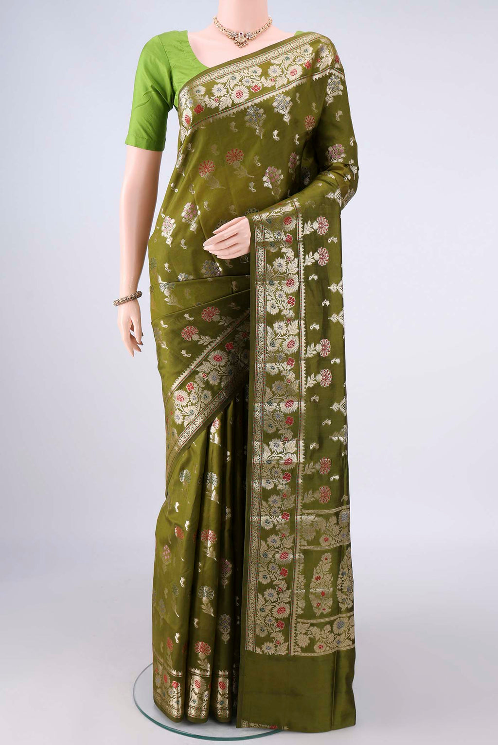 Pure Silk Mehandi Green Banarasi Raw Saree with Zari And Thread Butta on the body and Zari Border.  displayed on a mannequin