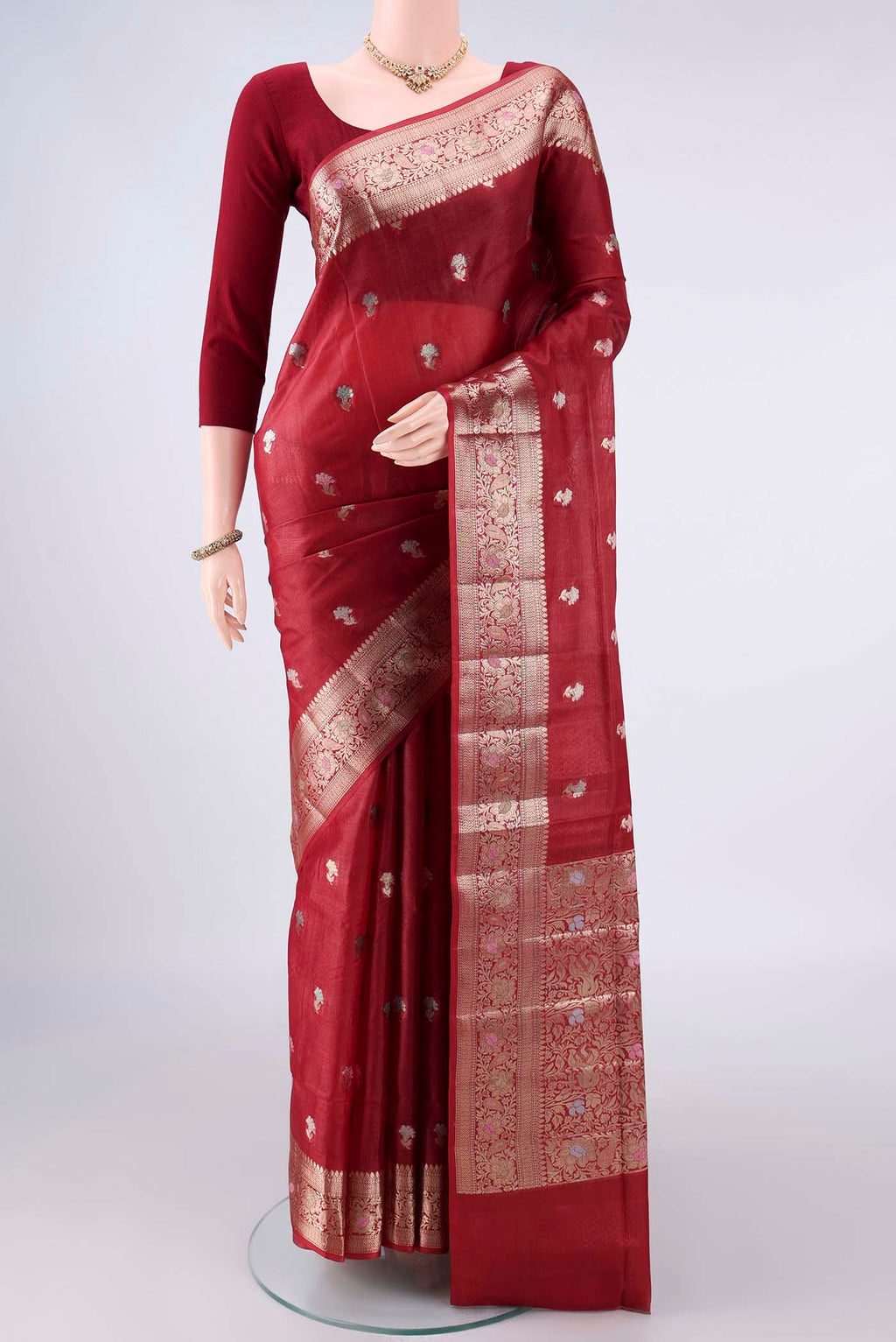 Rust Banarasi Raw Saree with Zari And Thread Butta on the body and Zari And Thread Border.  displayed on a mannequin