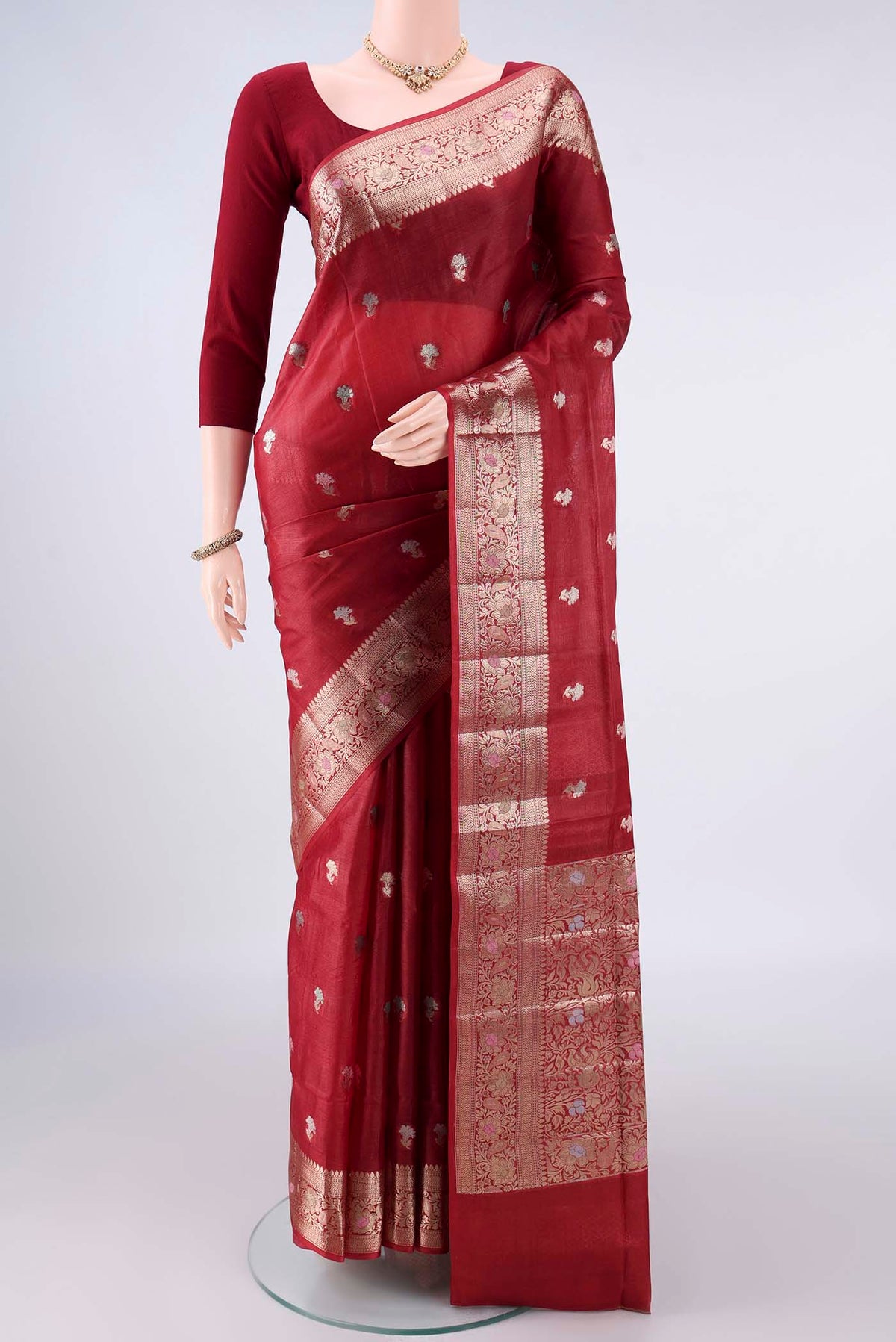 Rust Banarasi Raw Saree with Zari And Thread Butta on the body and Zari And Thread Border.  displayed on a mannequin