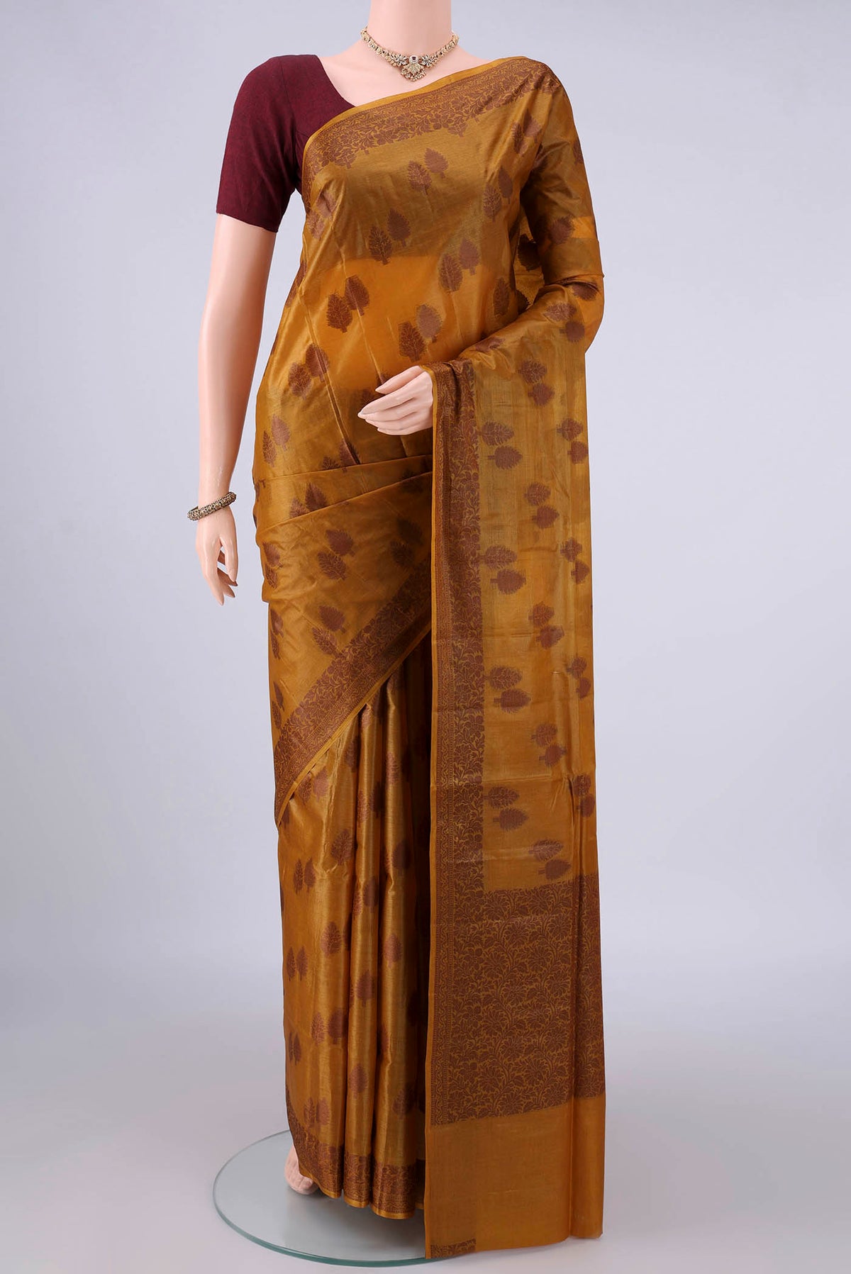 Mustard Banarasi Tussar Saree with Thread Butta on the body and Thread Border.  displayed on a mannequin