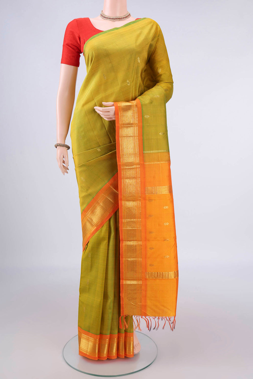 Pure Silk Acid Green Kanjivaram Saree with Zari Butta on the body and One Side Border.  displayed on a mannequin