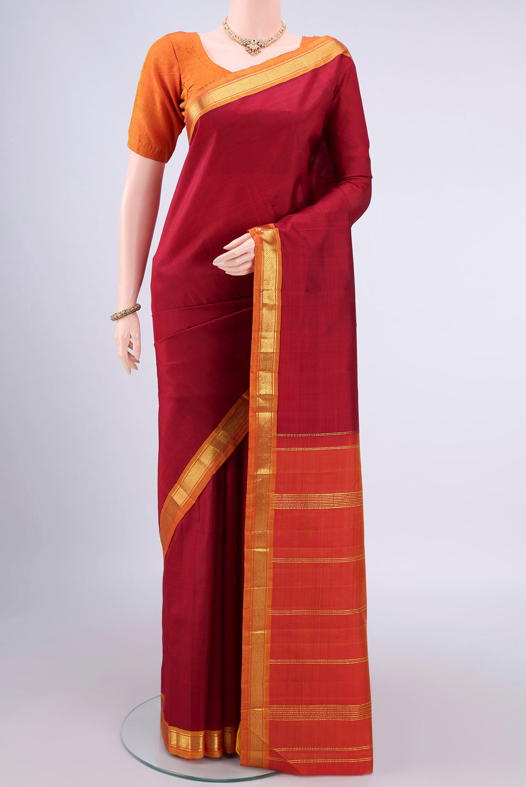 Pure Silk Red Kanjivaram Saree with Plain Body and Zari Border.  displayed on a mannequin