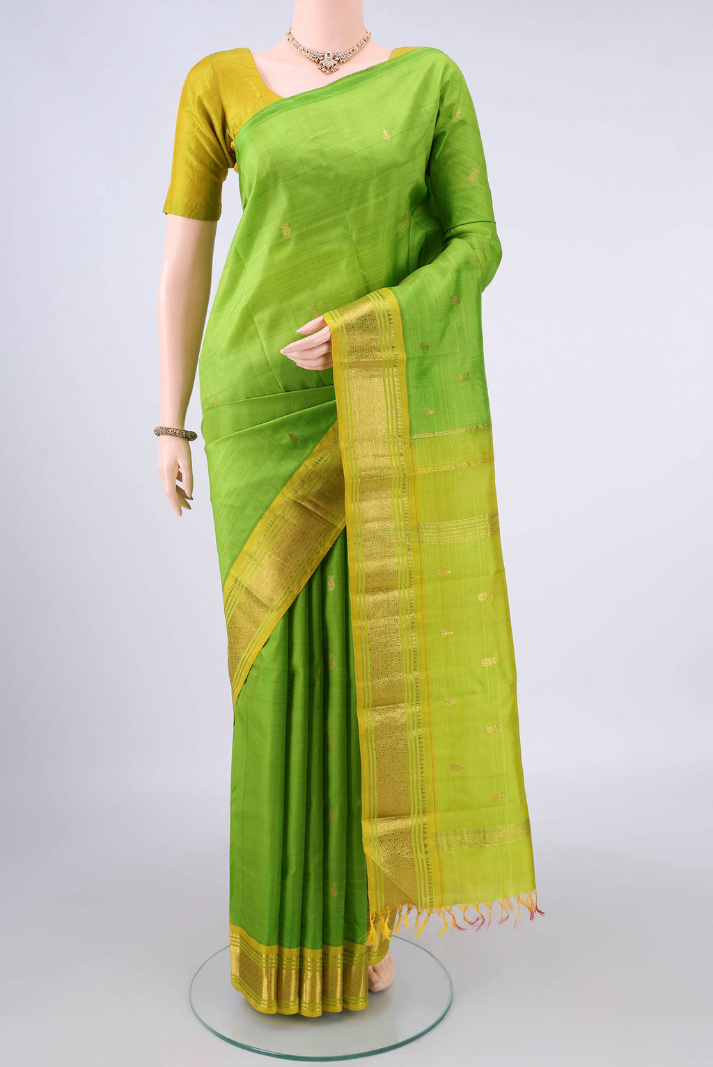 Pure Silk Parrot Green Kanjivaram Saree with Zari Butta on the body and One Side Border.  displayed on a mannequin
