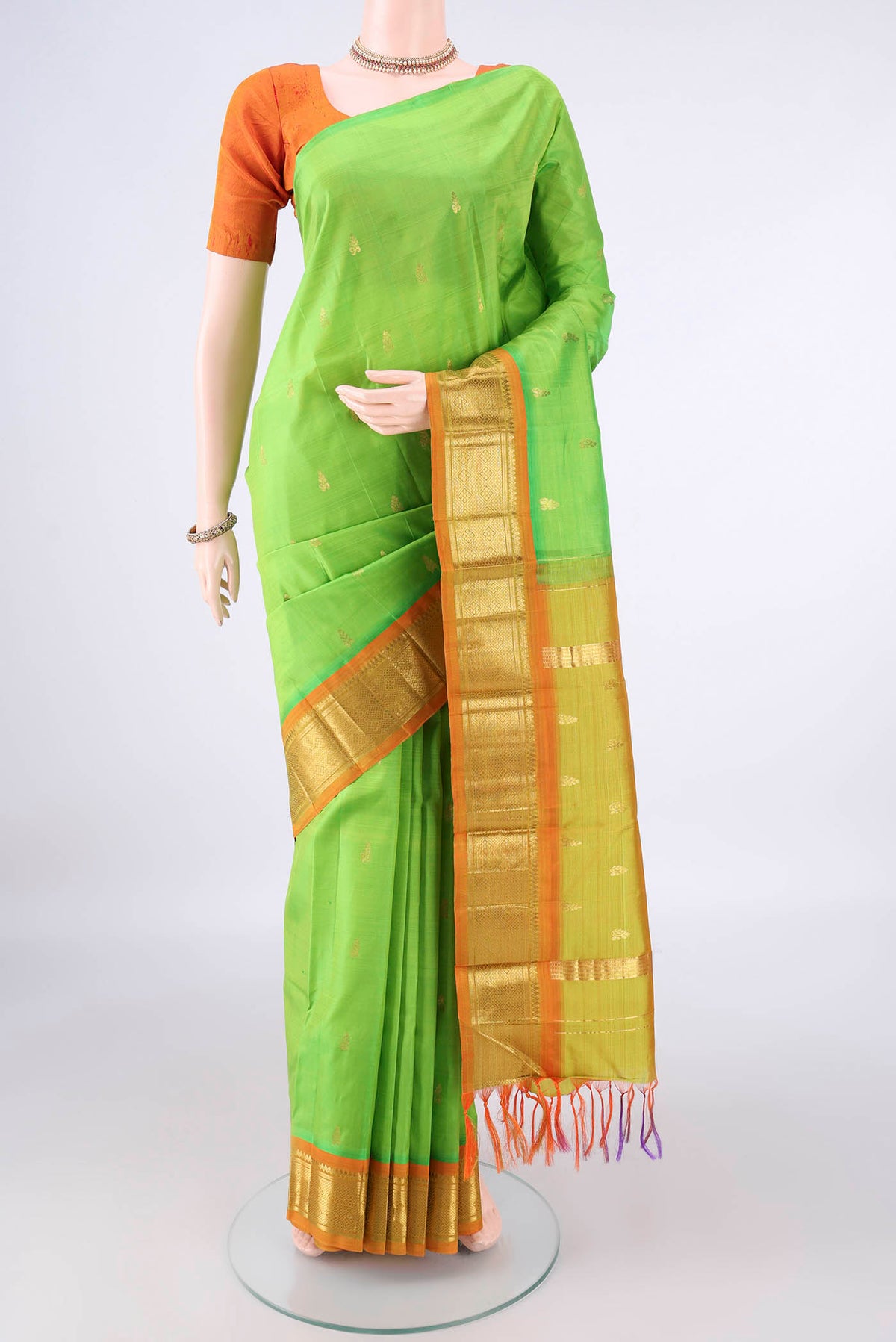 Pure Silk Parrot Green Kanjivaram Saree with Zari Butta on the body and One Side Border.  displayed on a mannequin
