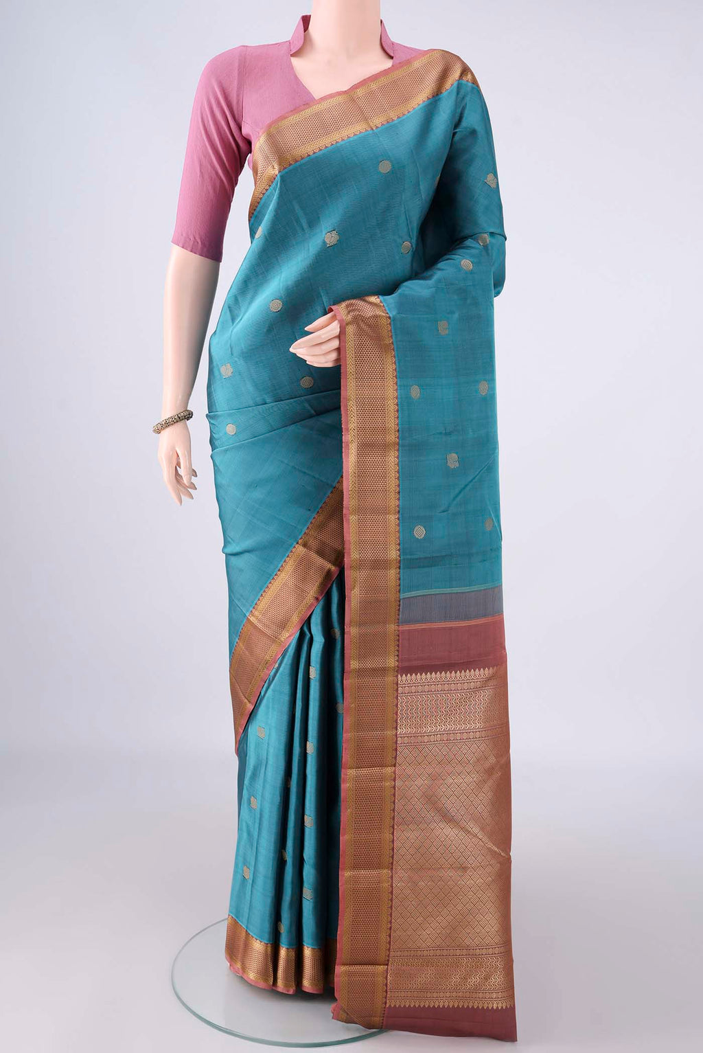 Pure Silk Teal Kanjivaram Saree with Thread Butta on the body and Thread Border.  displayed on a mannequin