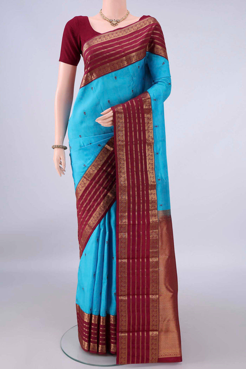 Pure Silk Sky Blue Kanjivaram Saree with Thread Butta on the body and Zari Border.  displayed on a mannequin