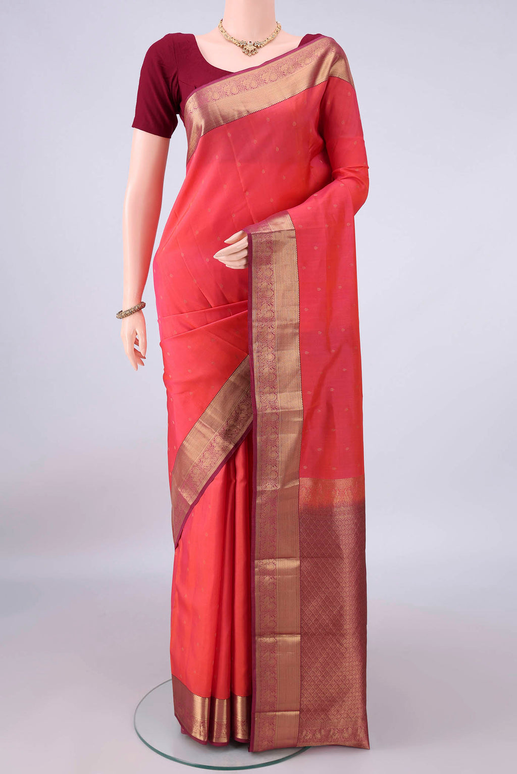 Pure Silk Brick Orange Kanchipuram Saree with Zari Butta on the body and Zari Border.  displayed on a mannequin