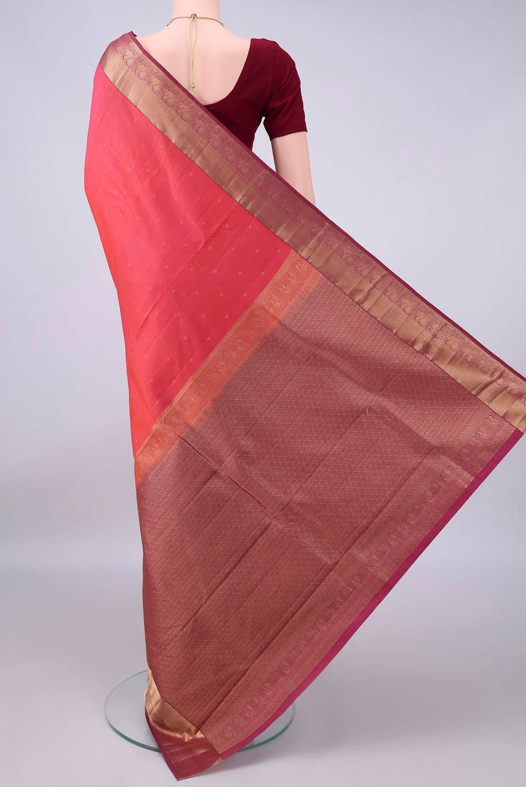 Flat view of Pure Silk Brick Orange Kanchipuram Saree with Zari Butta on the body and Zari Border. 