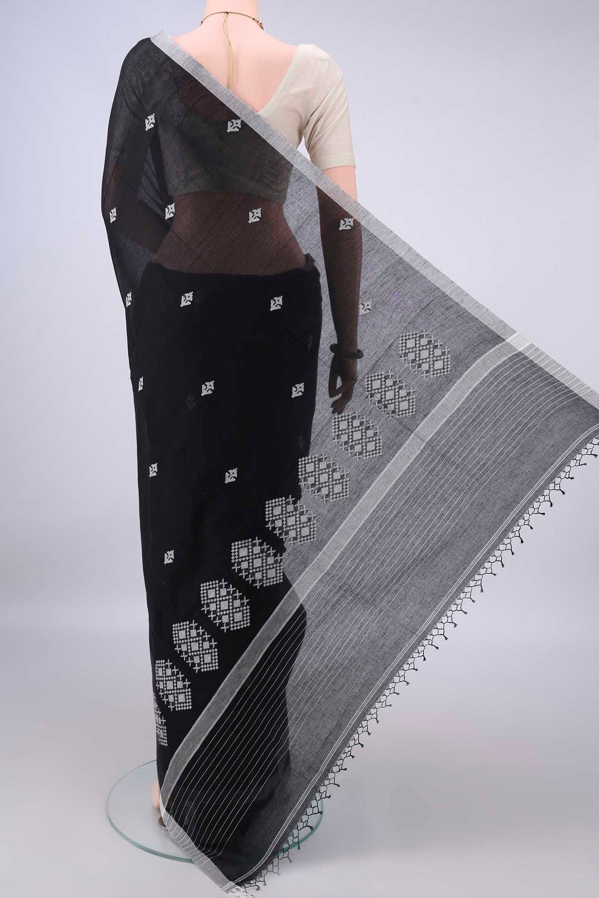 Flat view of Black Bengal Cotton Saree with Thread Butta on the body and Plain Border. 