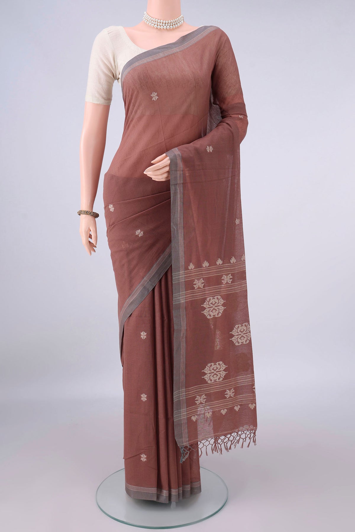 Brown Bengal Cotton Saree with Thread Butta on the body and Plain Border.  displayed on a mannequin