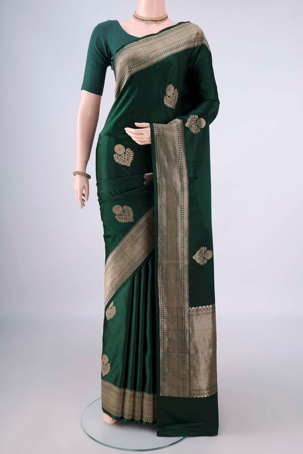 Bottle Green Banarasi Saree with Zari Butta on the body and Zari Border.  displayed on a mannequin