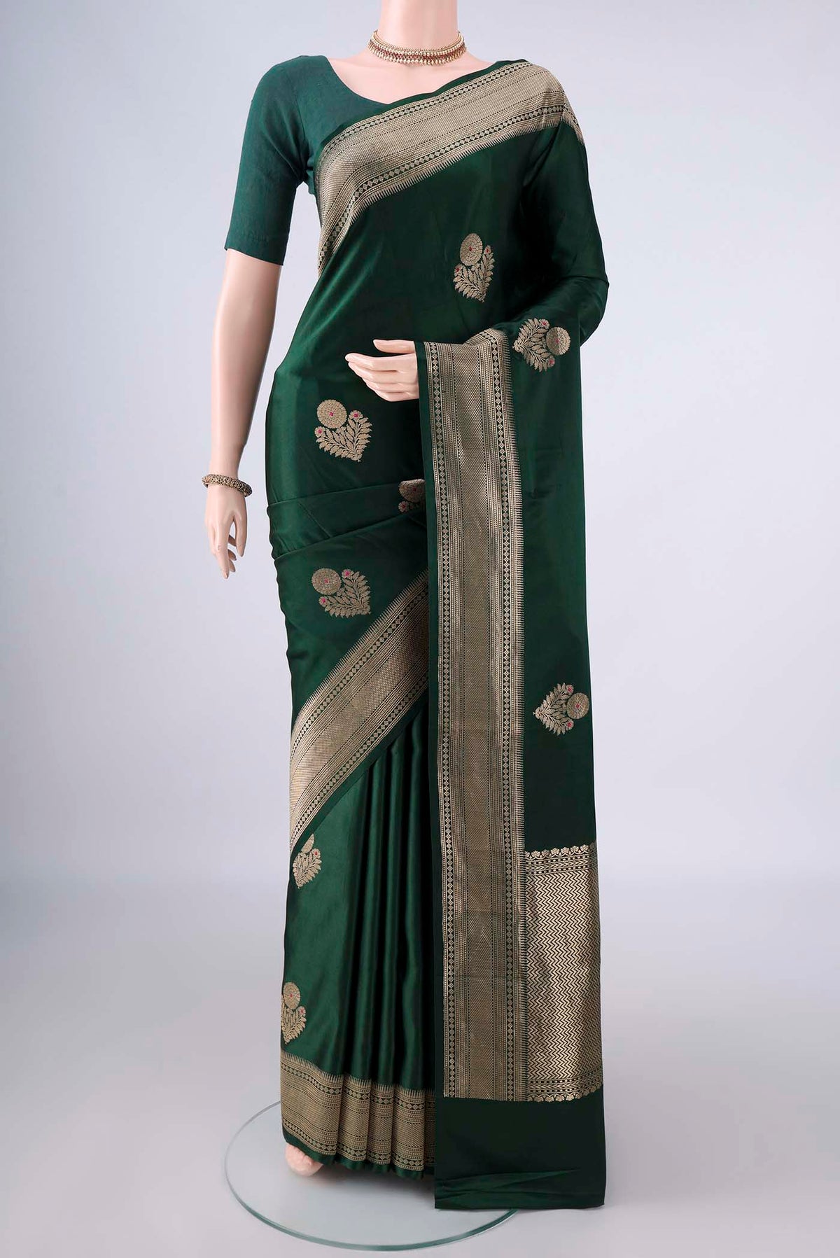 Bottle Green Banarasi Saree with Zari Butta on the body and Zari Border.  displayed on a mannequin