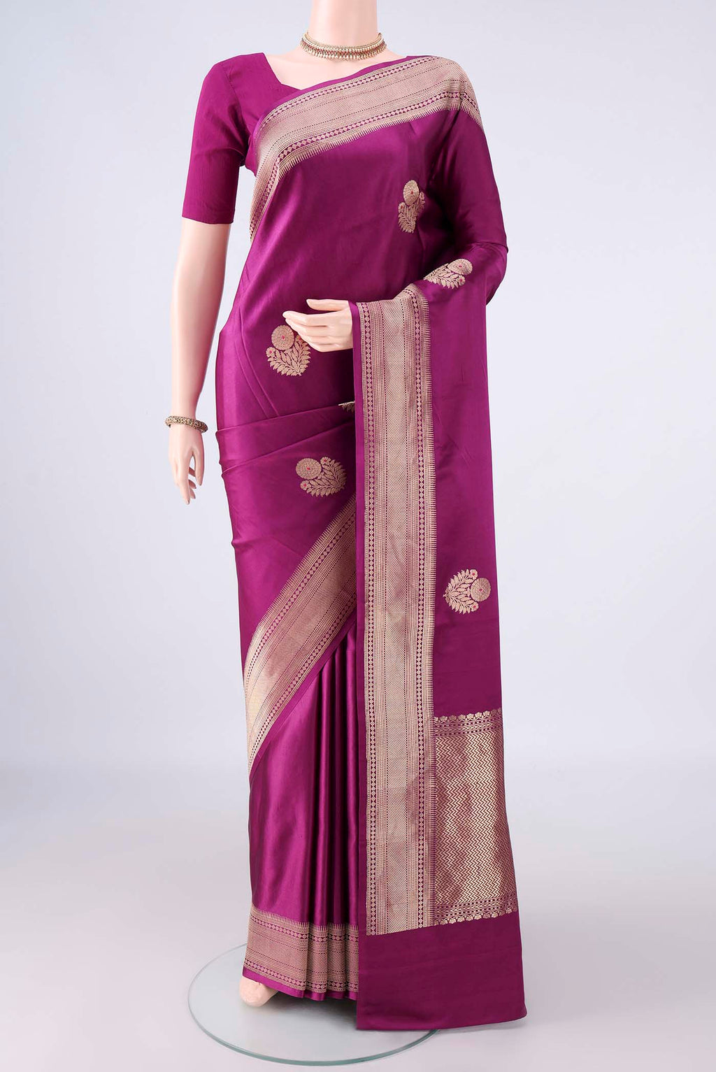 Magenta Banarasi Saree with Zari Butta on the body and Zari Border.  displayed on a mannequin