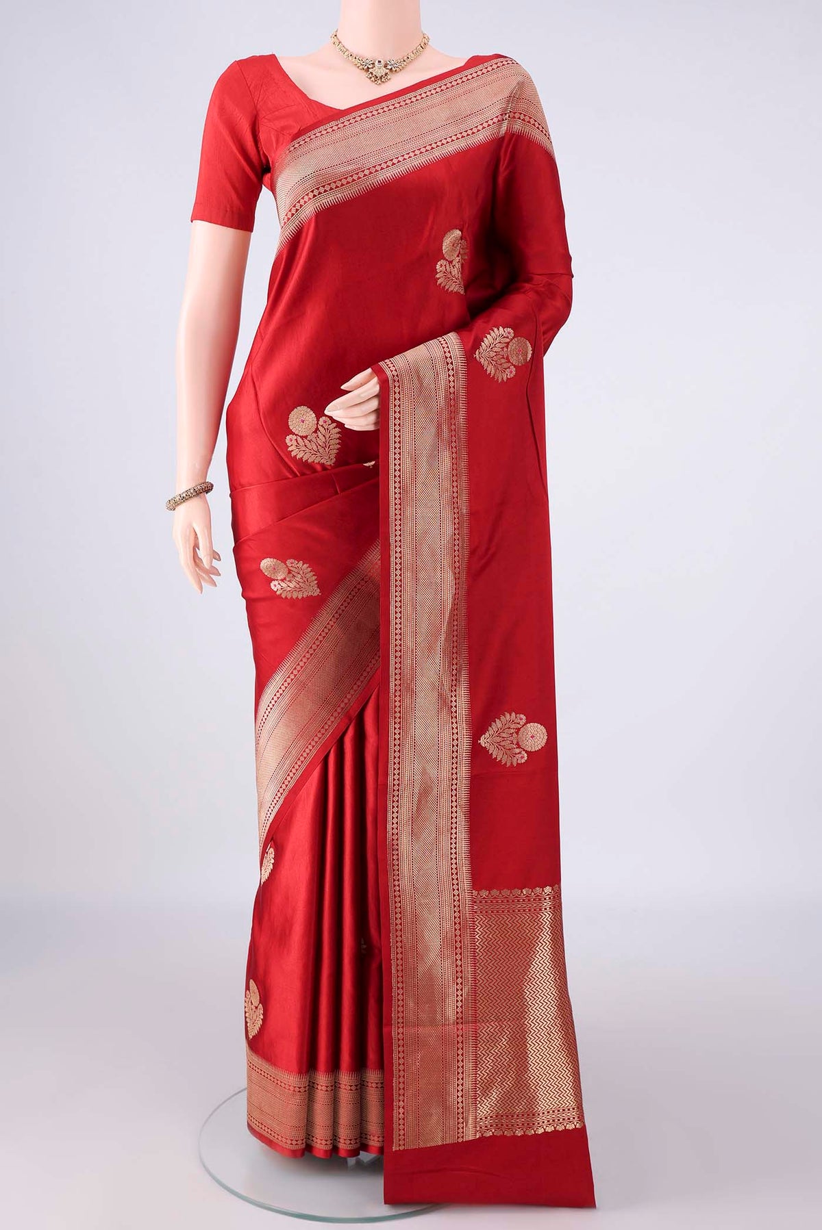 Red Banarasi Saree with Zari Butta on the body and Zari Border.  displayed on a mannequin