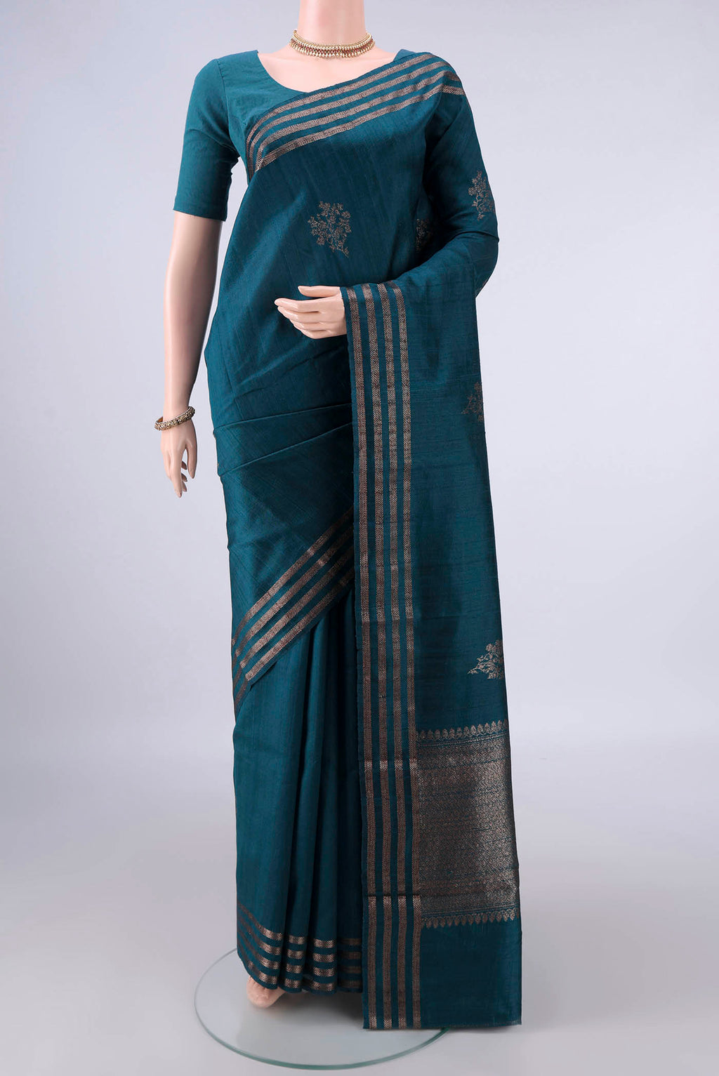 Peacock Blue Banarasi Katan Saree with Zari Butta on the body and Zari Border.  displayed on a mannequin
