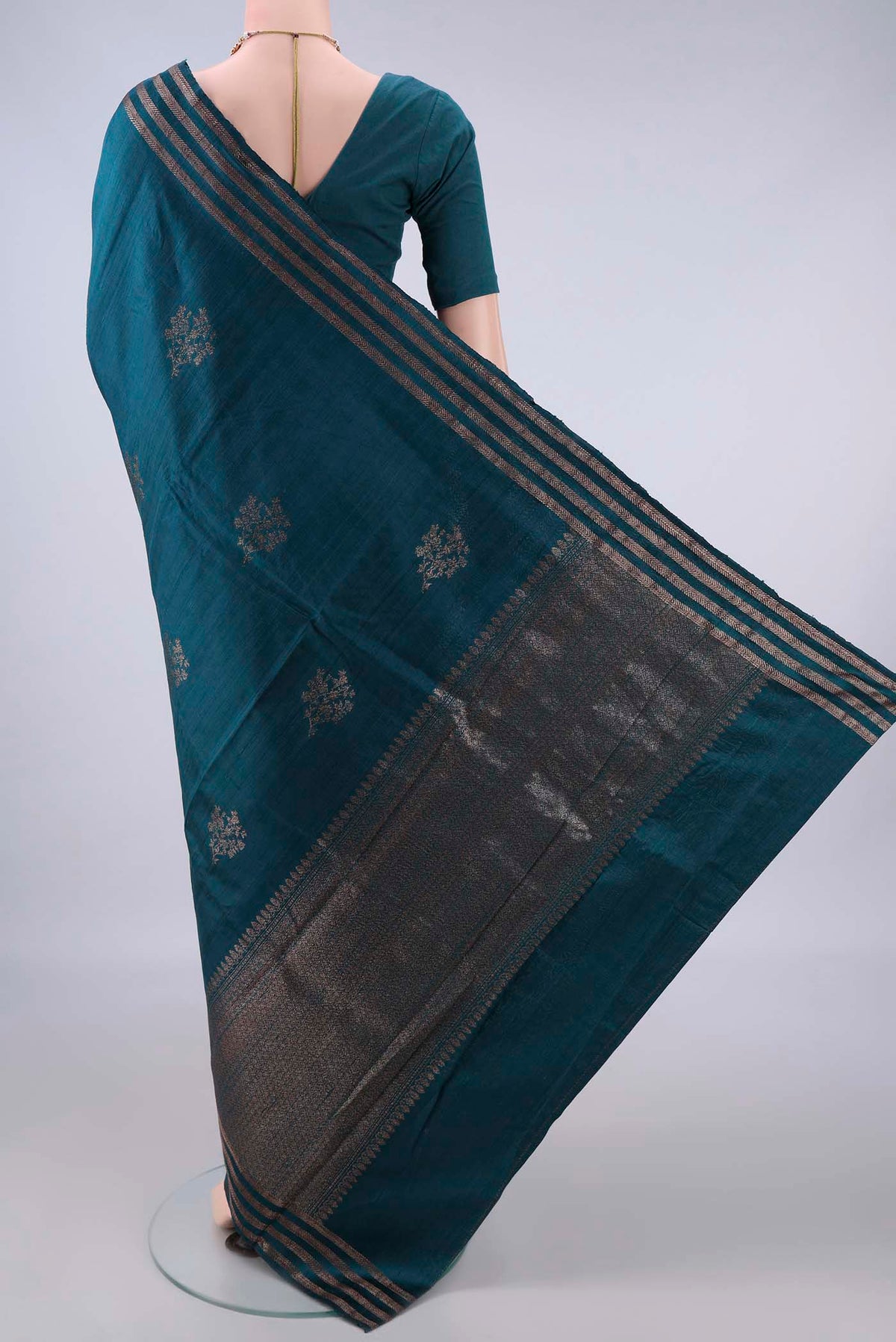 Flat view of Peacock Blue Banarasi Katan Saree with Zari Butta on the body and Zari Border. 