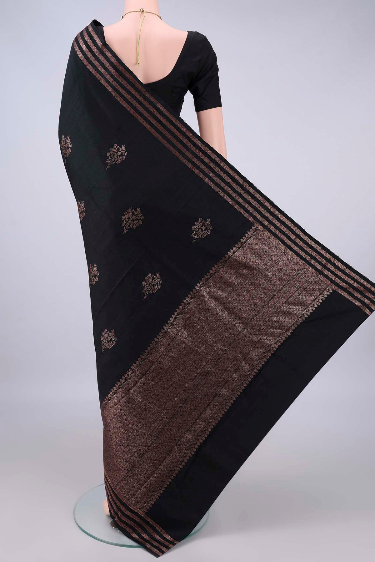 Flat view of Black Banarasi Tussar Saree with Zari Butta on the body and Zari Border. 