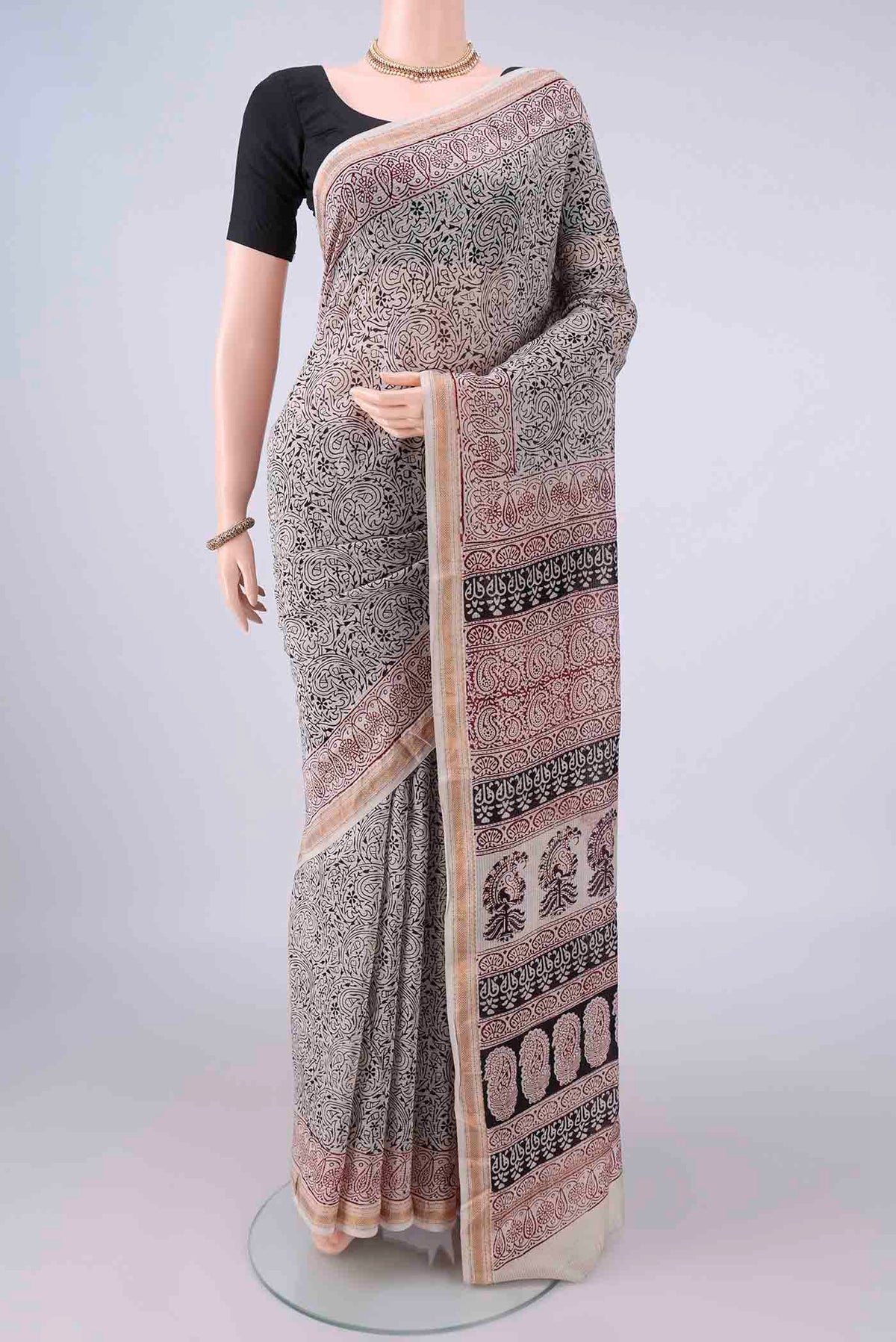 Cream Maheshwari Cotton Saree with Printed design on the body and Zari Border.  displayed on a mannequin