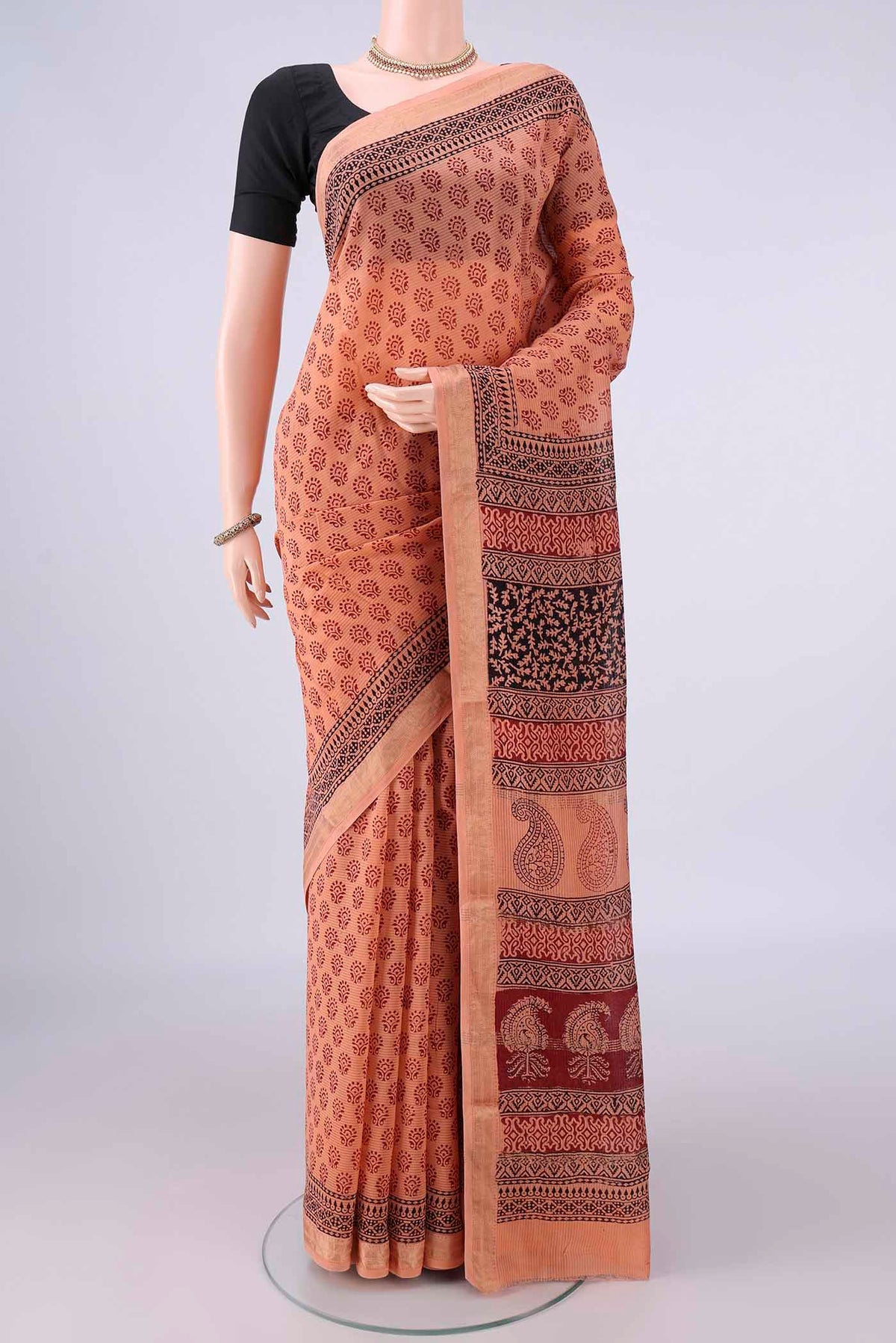 Peach Maheshwari Cotton Saree with Printed design on the body and Zari Border.  displayed on a mannequin