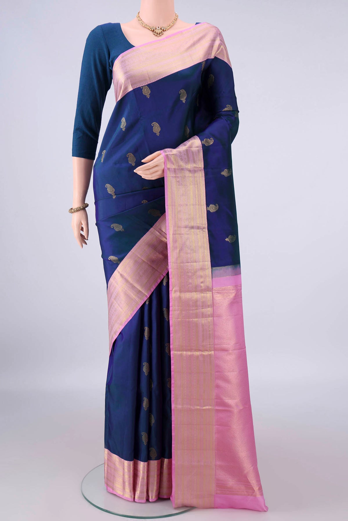 Pure Silk Navy Blue Kanchipuram Saree with Zari Butta on the body and Zari Border.  displayed on a mannequin