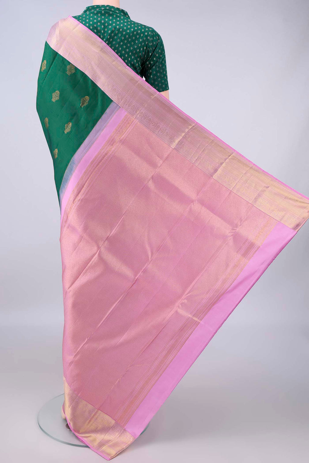 Flat view of Pure Silk Bottle Green Kanchipuram Saree with Zari Butta on the body and Zari Border. 