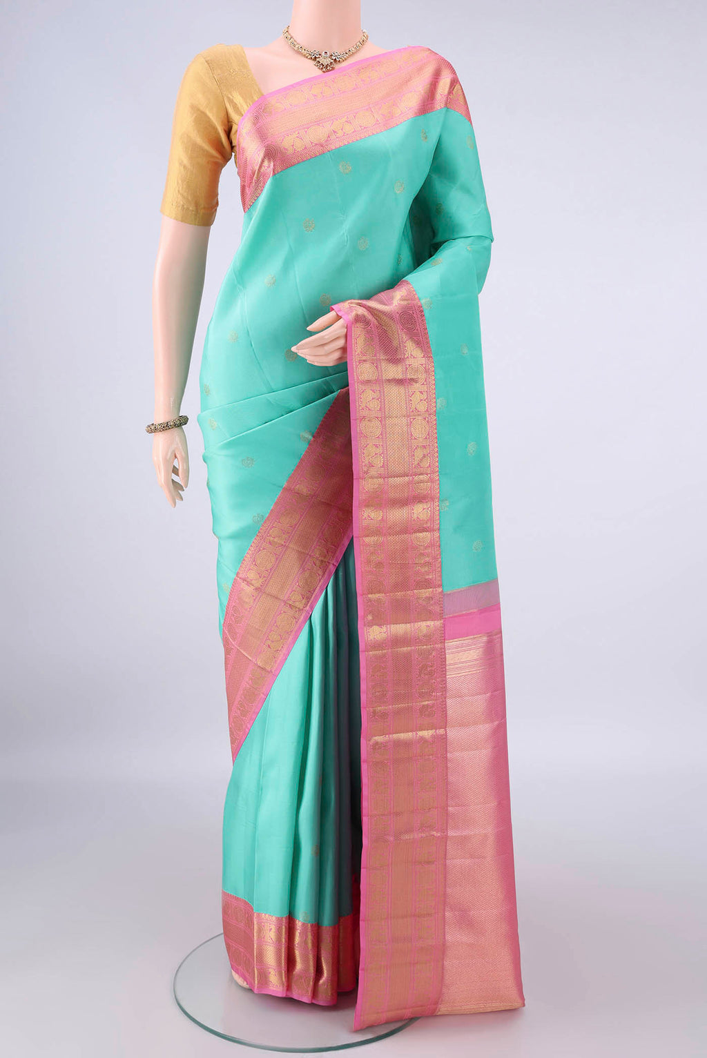 Pure Silk Turquoise Kanchipuram Saree with Zari Butta on the body and Zari Border.  displayed on a mannequin