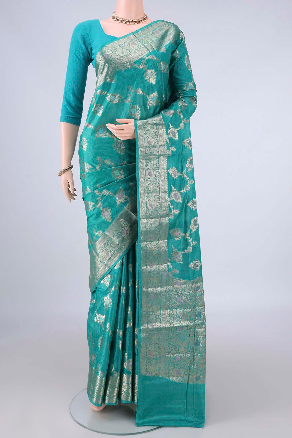 Turquoise Banarasi Tussar Saree with Zari And Thread Butta on the body and Zari And Thread Border.  displayed on a mannequin