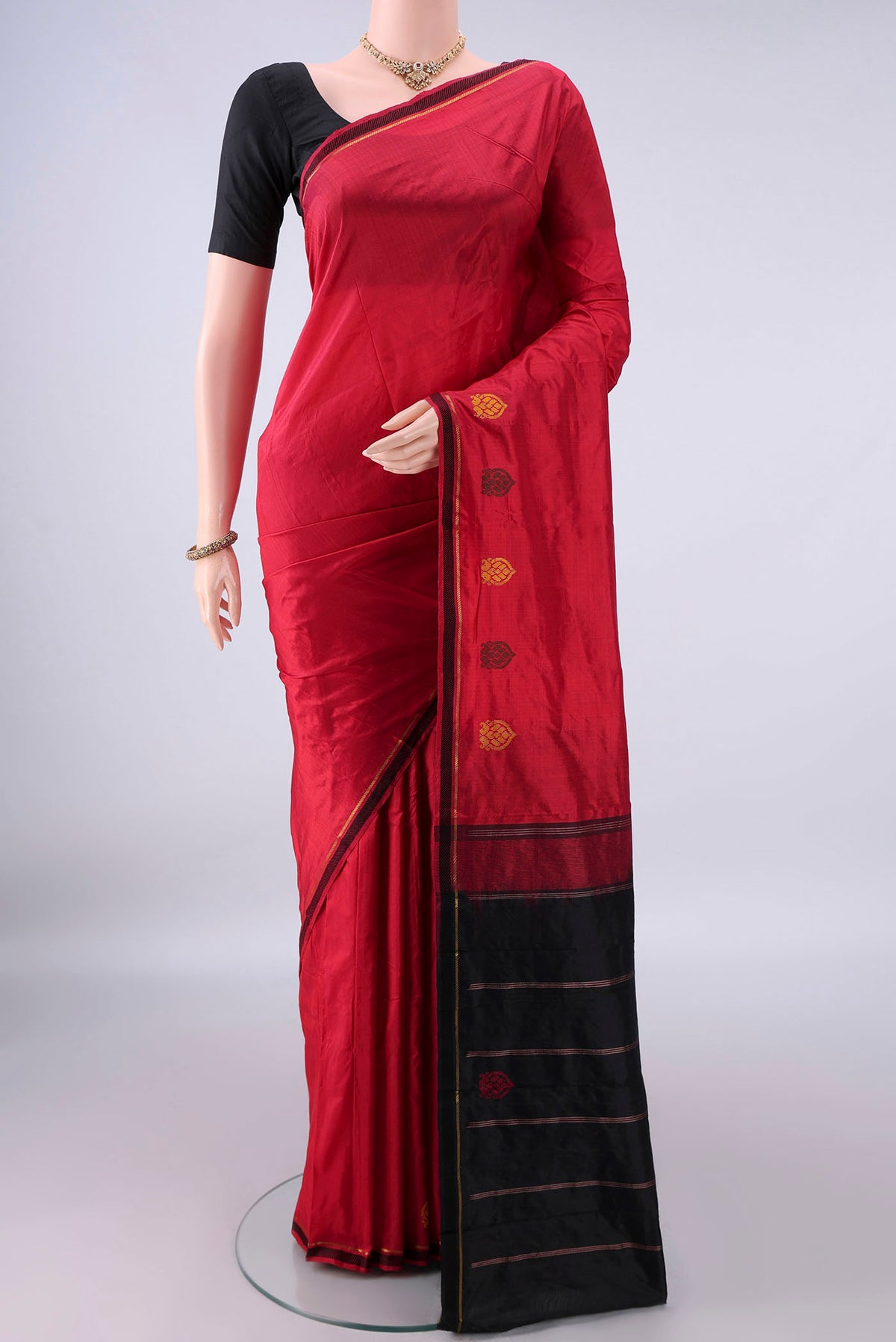 Pure Silk Red Kanchipuram Saree with Plain Body and Zari Border.  displayed on a mannequin