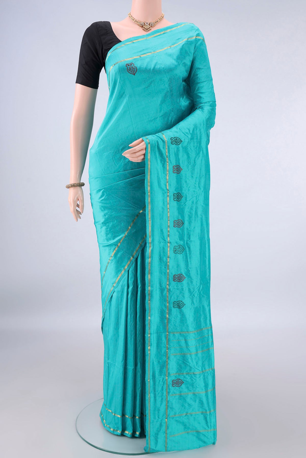 Pure Silk Turquoise Kanchipuram Saree with Plain Body and Zari Border.  displayed on a mannequin