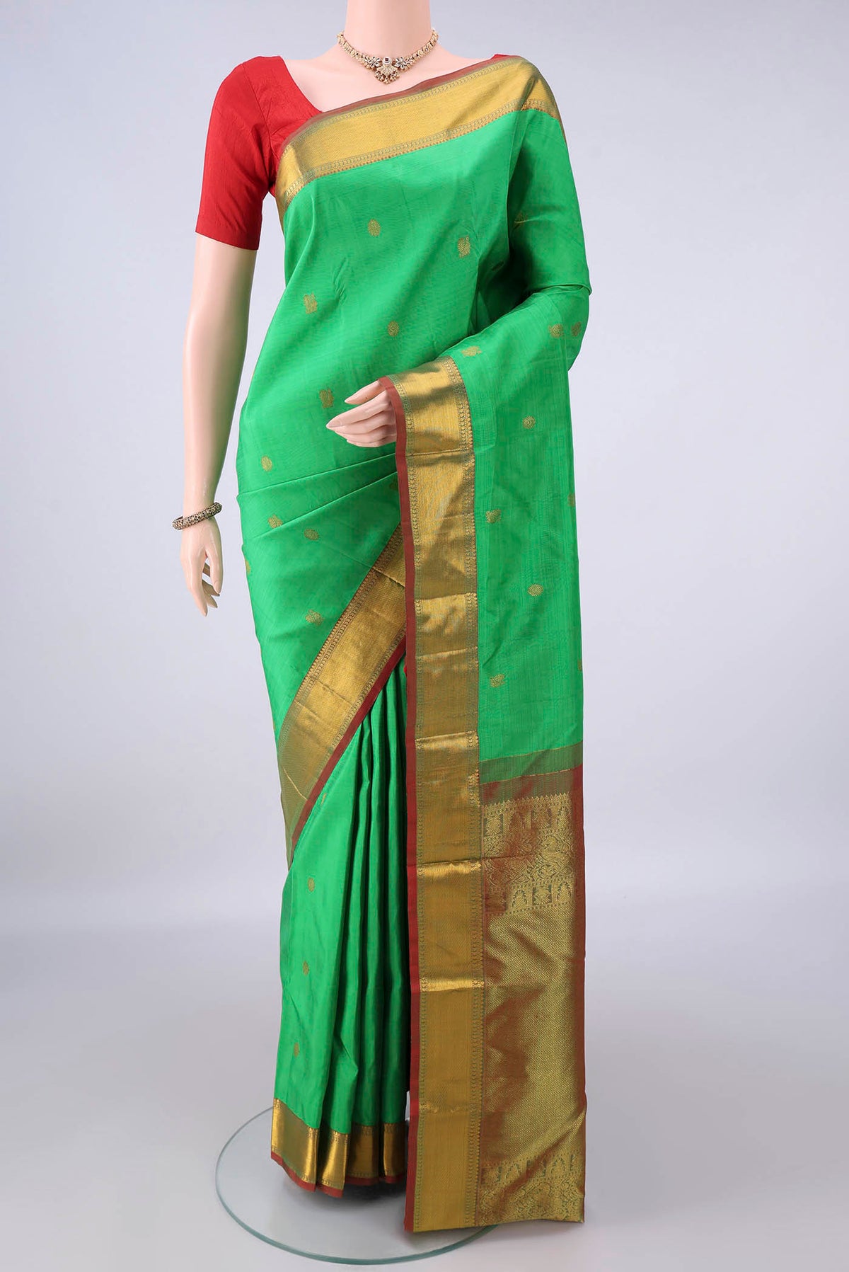 Pure Silk Green Kanchipuram Saree with Zari Butta on the body and Zari Border.  displayed on a mannequin