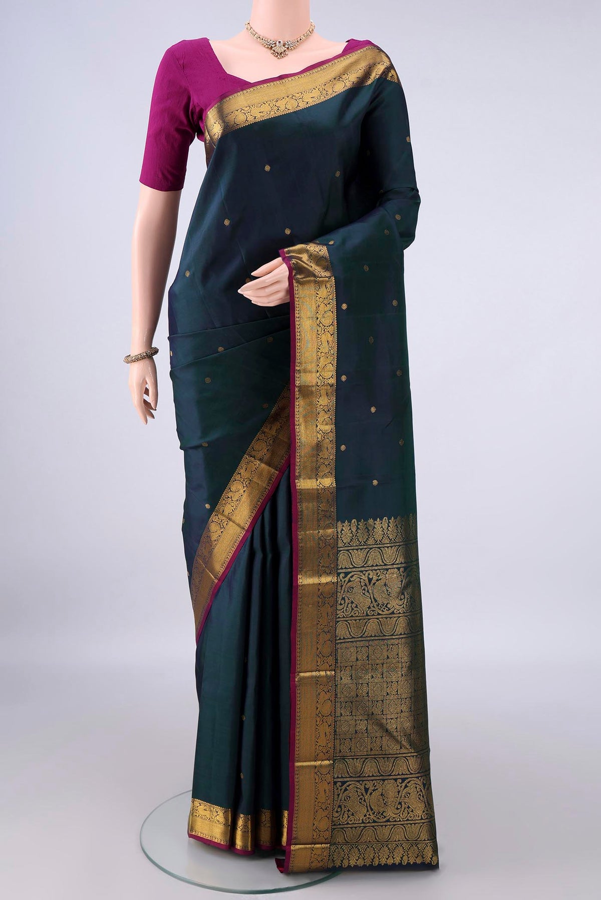 Pure Silk Bottle Green Dual Tone Kanchipuram Saree with Zari Butta on the body and Zari Border.  displayed on a mannequin