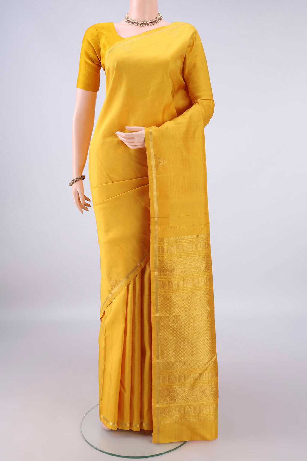 Pure Silk Yellow Kanchipuram Saree with Plain Body and Zari Border.  displayed on a mannequin
