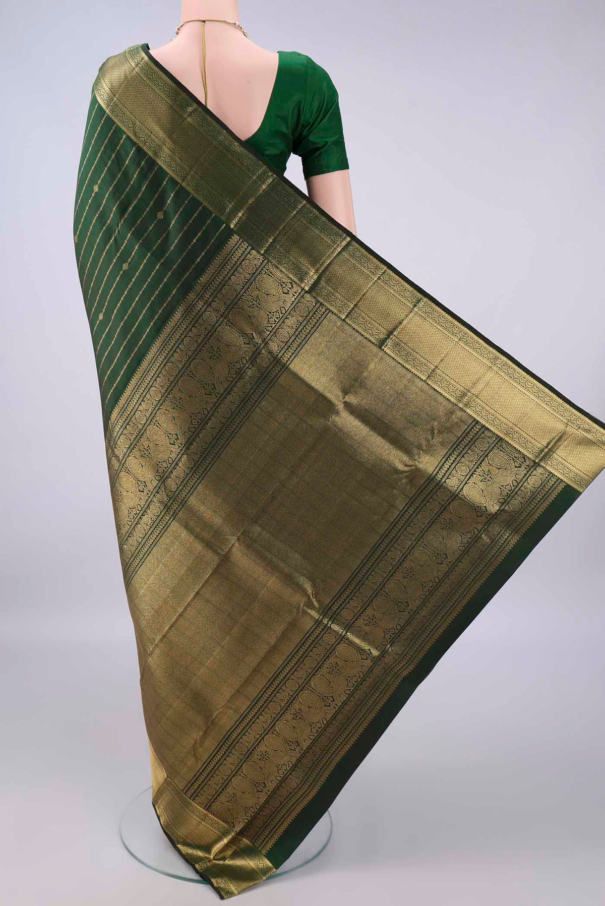 Flat view of Pure Silk Bottle Green Kanchipuram Saree with Stripes on the body and Zari Border. 