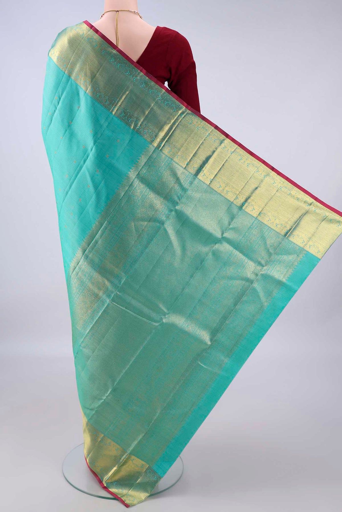 Flat view of Pure Silk Turquoise Kanjivaram Saree with Zari Butta on the body and Zari Border. 