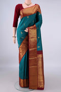Pure Silk Peacock Blue Kanjivaram Saree with Zari Butta on the body and Zari Border.  displayed on a mannequin