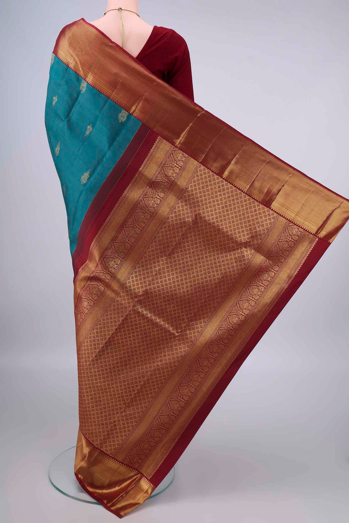 Flat view of Pure Silk Peacock Blue Kanjivaram Saree with Zari Butta on the body and Zari Border. 