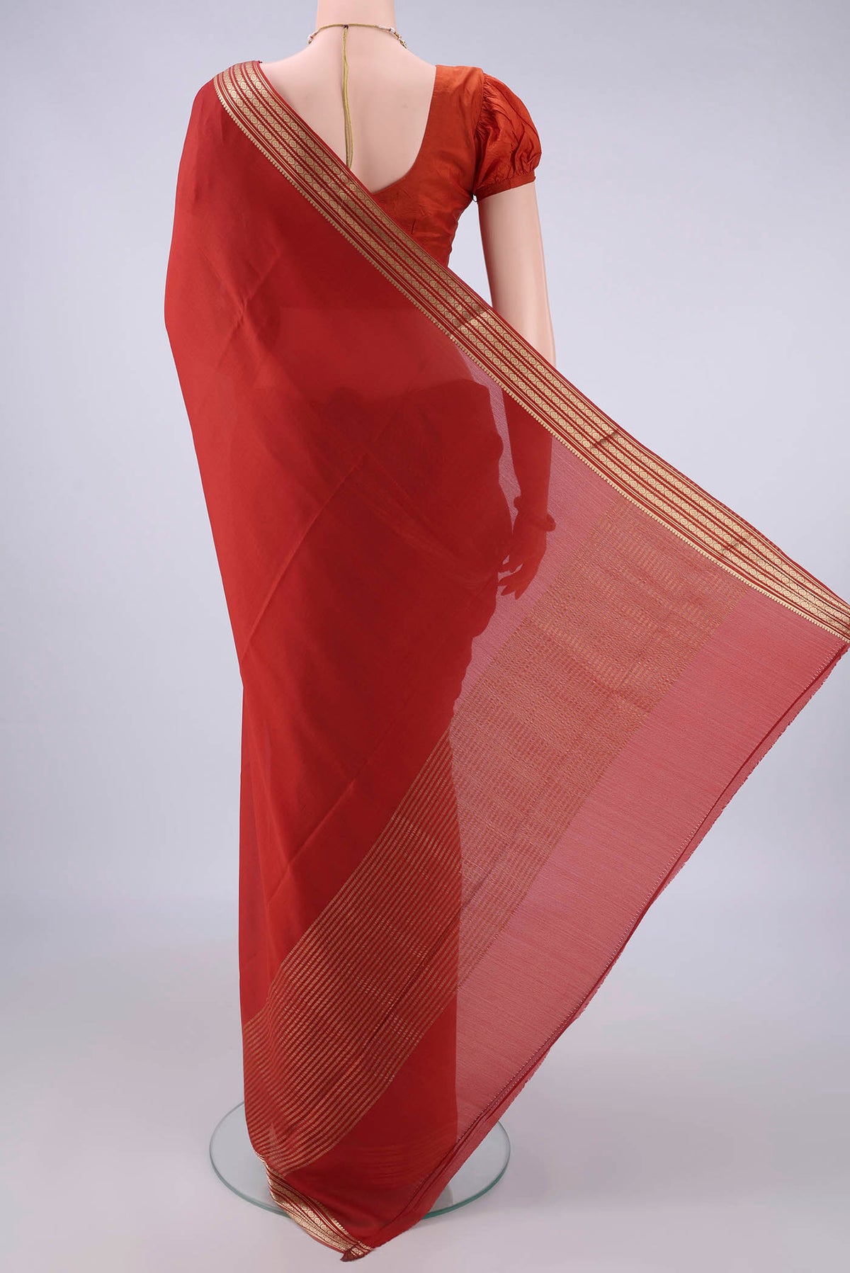 Flat view of Rust Mysore Crepe Saree with Plain Body and Zari Border. 