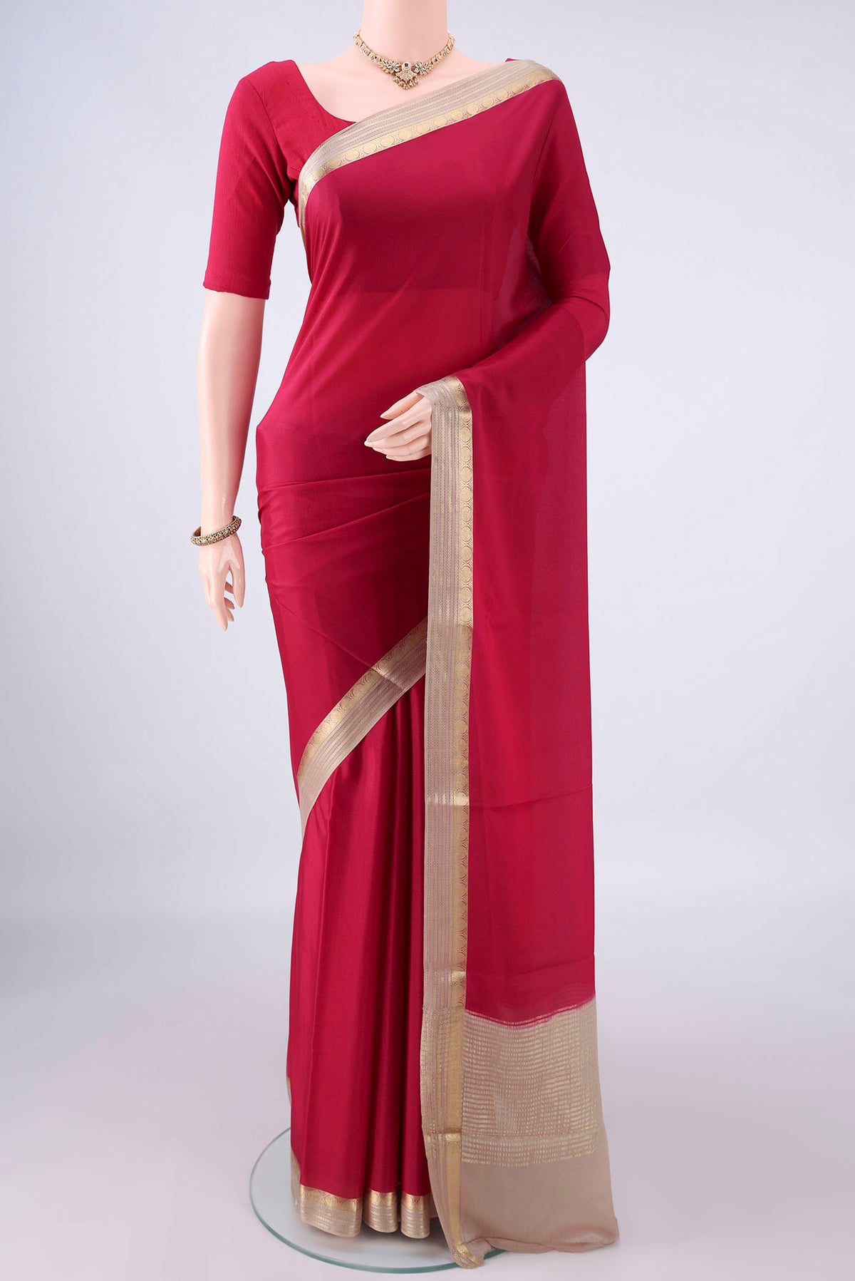 Deep Red Mysore Crepe Saree with Plain Body and Zari Border.  displayed on a mannequin