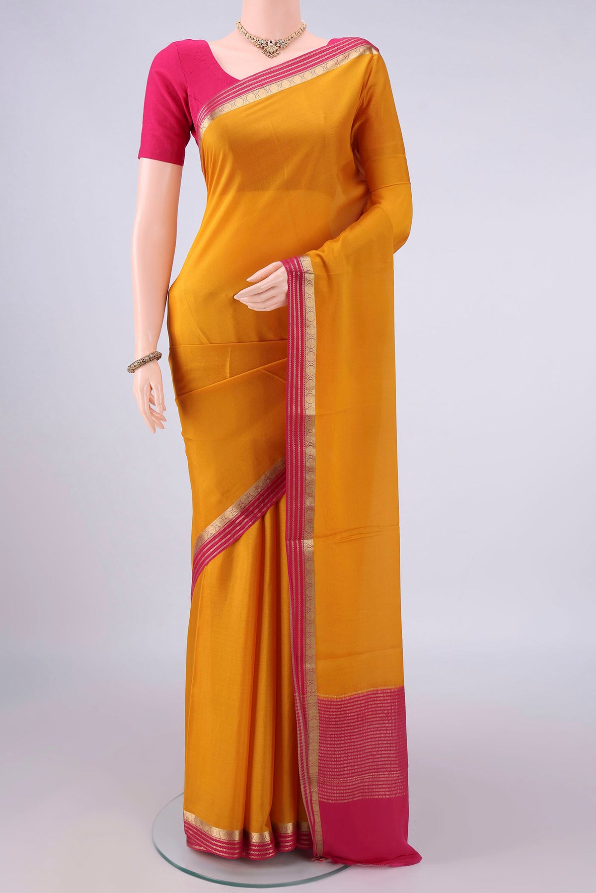 Mustard Mysore Crepe Saree with Plain Body and Zari Border.  displayed on a mannequin