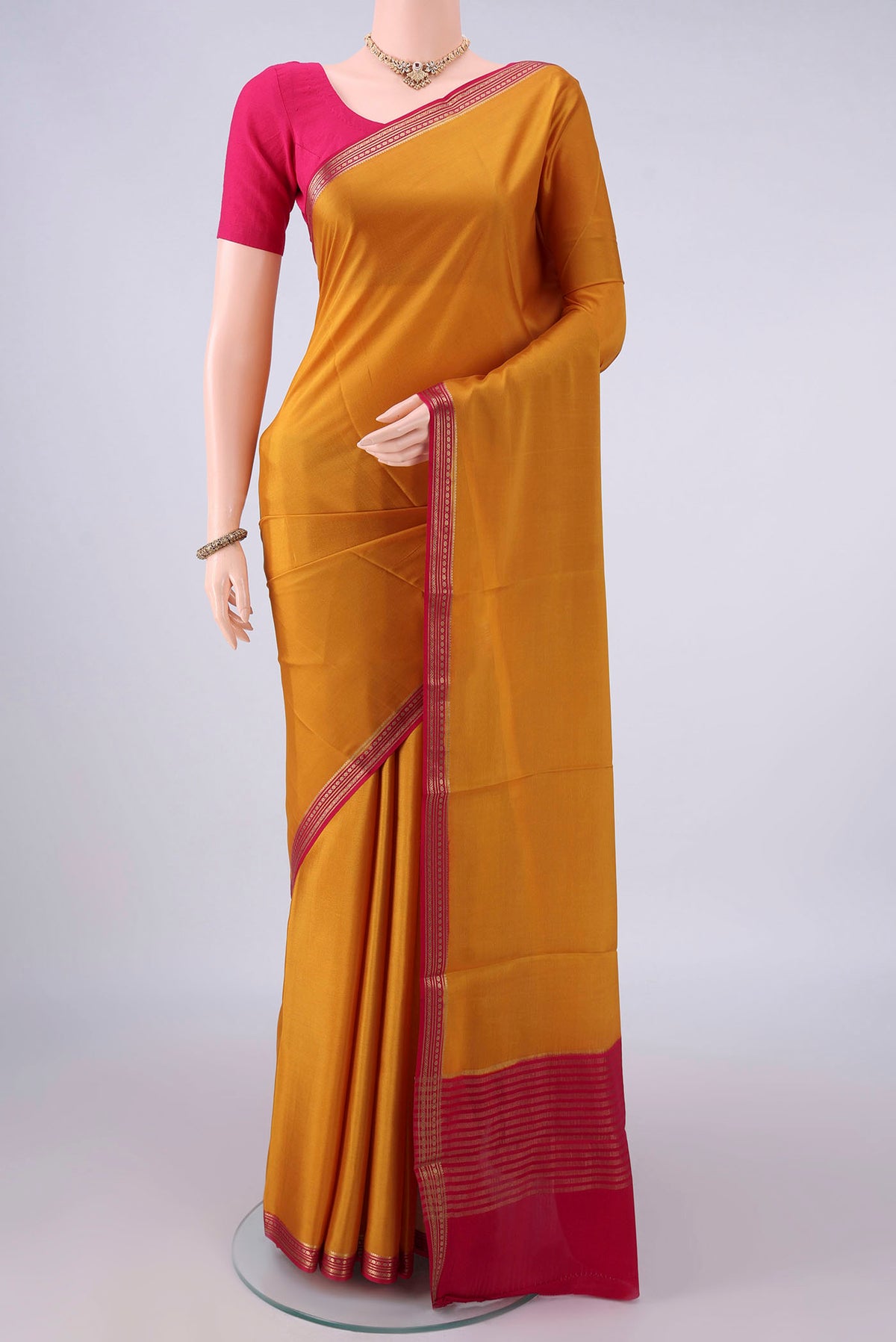 Mustard Mysore Crepe Saree with Plain Body and Zari Border.  displayed on a mannequin